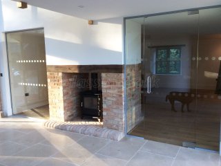Martin Haynes Construction, Domestic (Towcester, Northamptonshire): Frameless Glass Door and Wall Around Central Fireplace