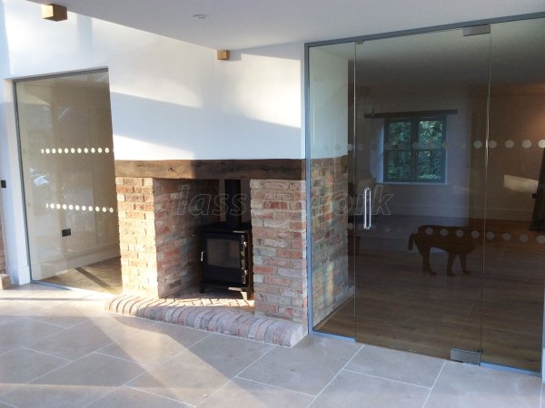 Martin Haynes Construction, Domestic (Towcester, Northamptonshire): Frameless Glass Door and Wall Around Central Fireplace