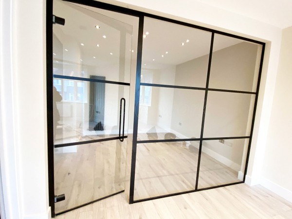 By Developments (Neasden, London): Industrial-Look Office Wall With Black Metal Frame and Toughened Glass
