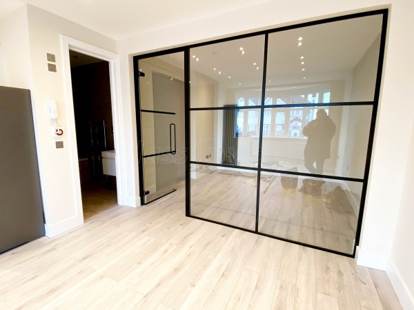 By Developments (Neasden, London): Industrial-Look Office Wall With Black Metal Frame and Toughened Glass